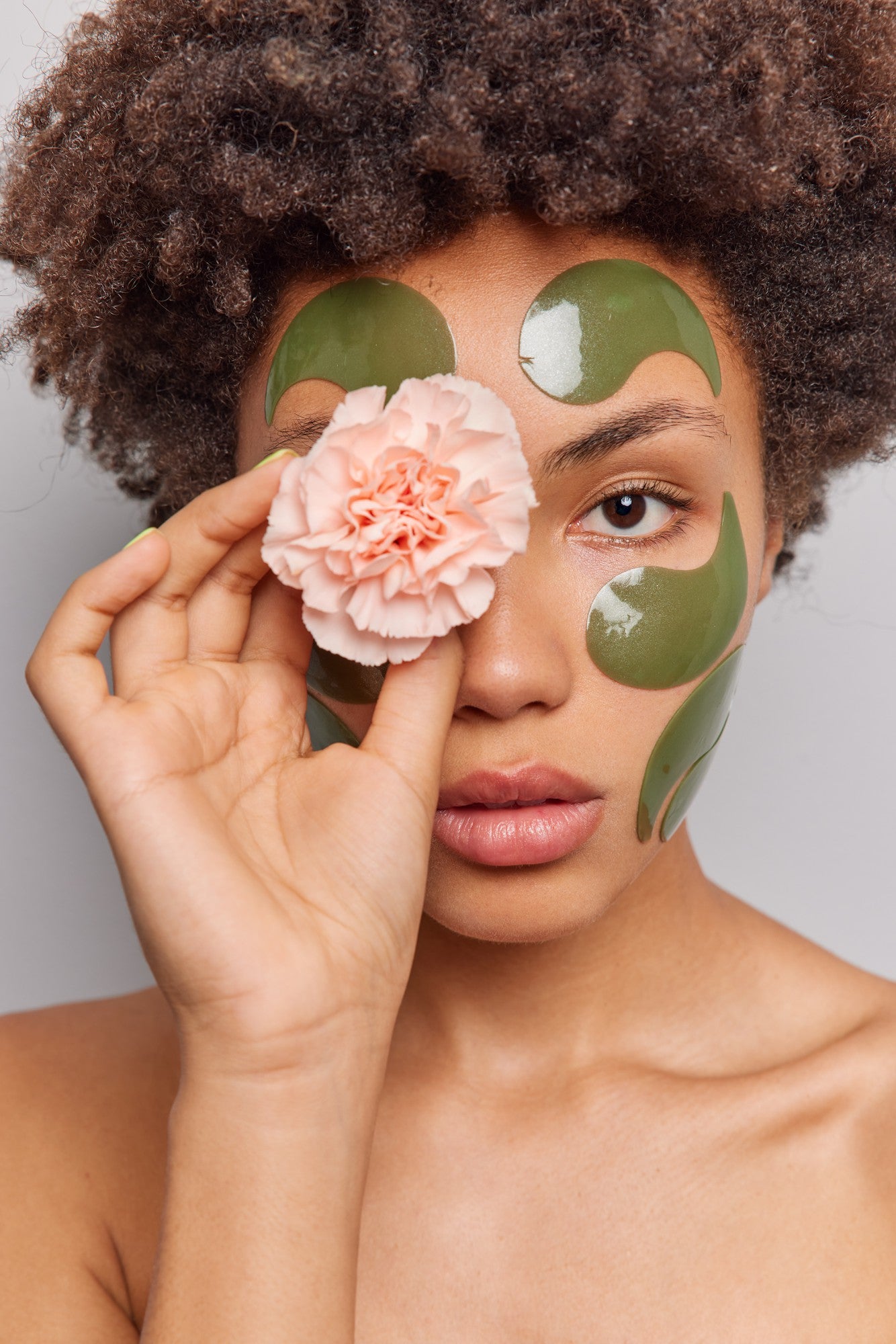 woman-uses-natural-beauty-products-holds-flower-eye-applies-collagen-green-patches-face-stands-shirtless-poses-indoor.jpg